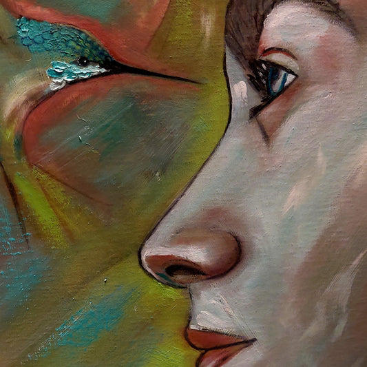 Detalle del rostro y cabeza de uno de los colibrís. Ámbos se miran a los ojos.